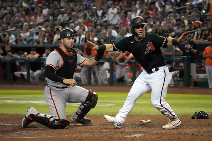 Dbacks outfielder Daulton Varsho and SF Giants catcher Joey Bart turn to the umpire after a play at the plate. (2022)